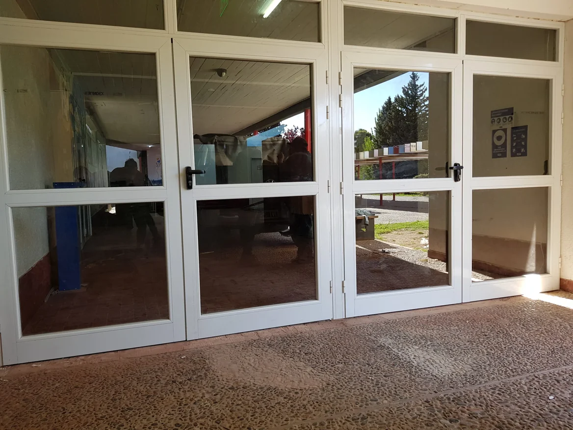 Puertas dobles de aluminio con vidrio en edificio institucional - JN Aluminio Neuquén