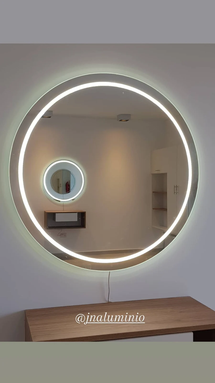 Espejo LED redondo con anillo de luz sobre mesada de madera - JN Aluminio Neuquén