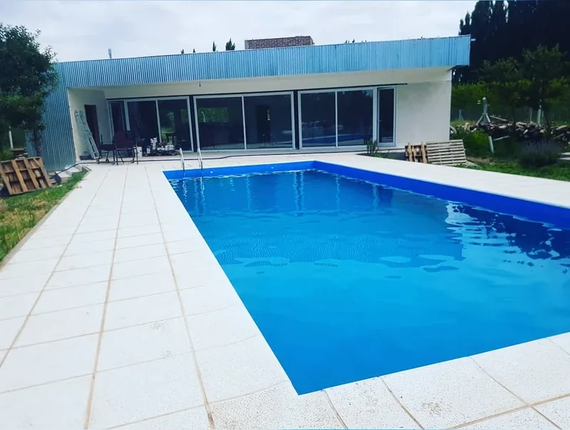 Vivienda con el frente completo en ventanales corredizos de aluminio frente a la pileta - obra de JN Aluminio en Neuquén