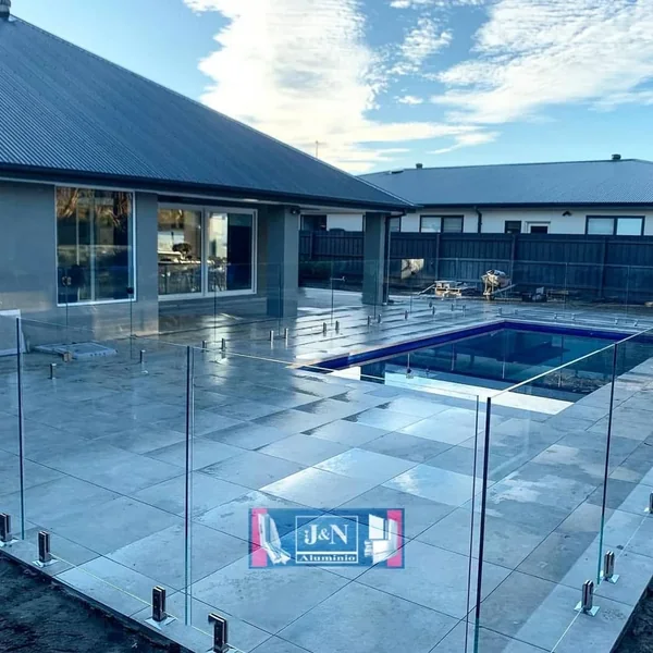 Baranda de vidrio templado perimetral en pileta con herrajes de acero inoxidable - obra de JN Aluminio en Neuquén
