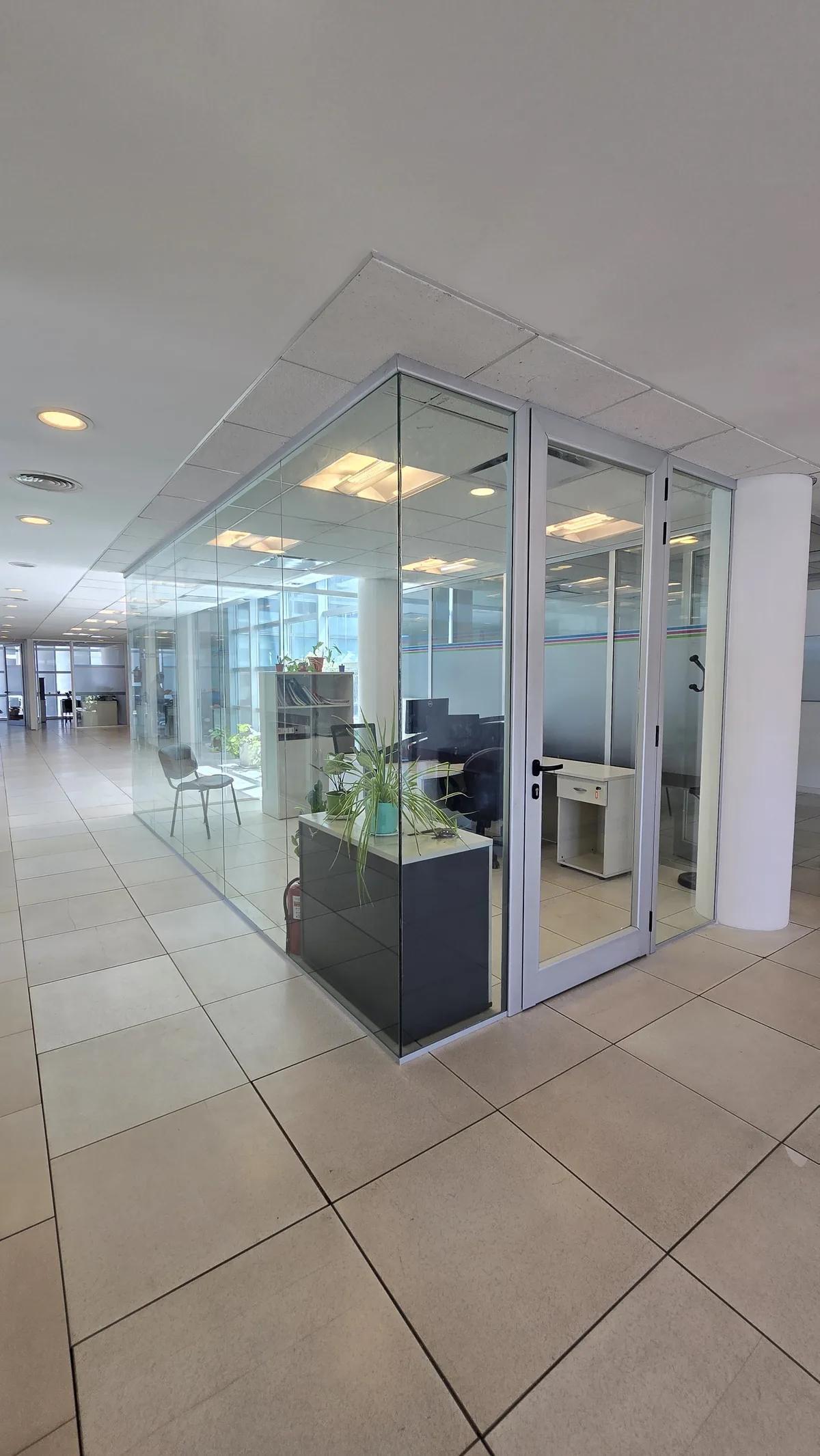 Oficina dividida con tabiques de vidrio de piso a techo y perfilería de aluminio - obra de JN Aluminio en Neuquén