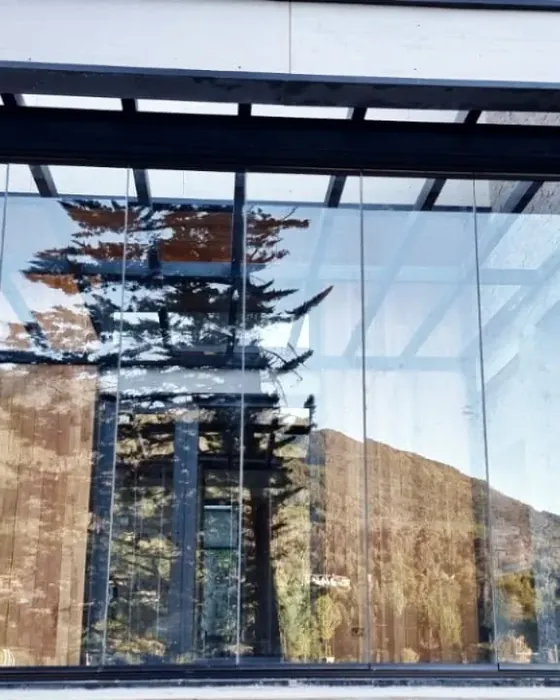 Cortina de cristal frameless en casa de montaña - obra de J&N Aluminio en Bahía Manzano, Villa La Angostura